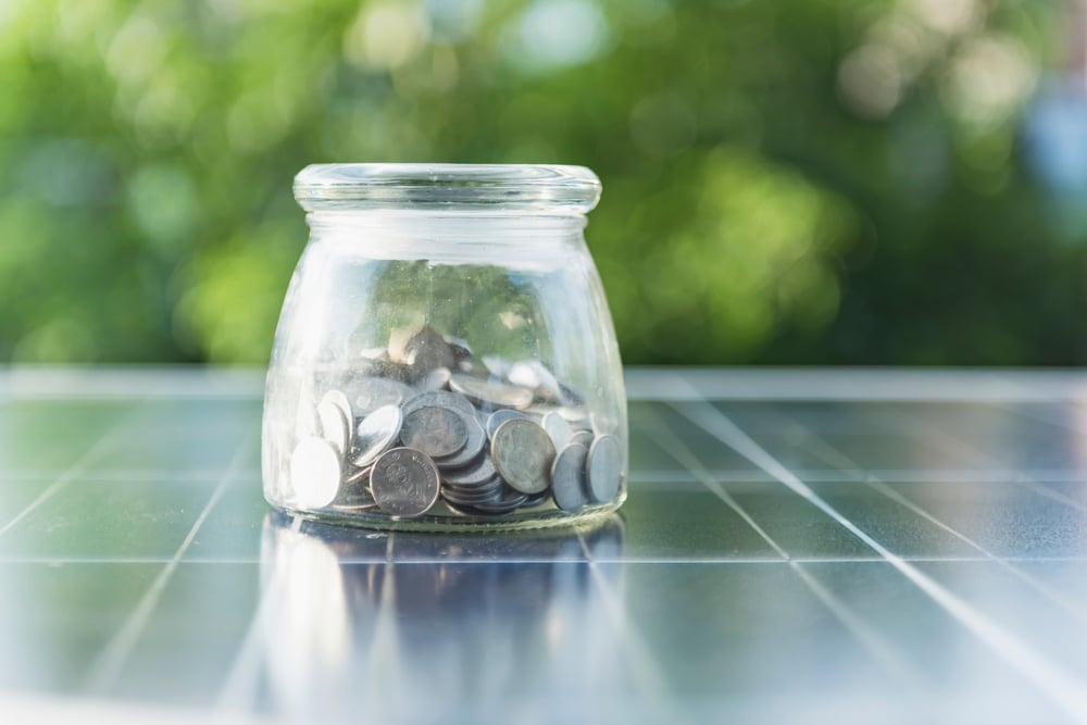 Jar of coins on top of solar panel