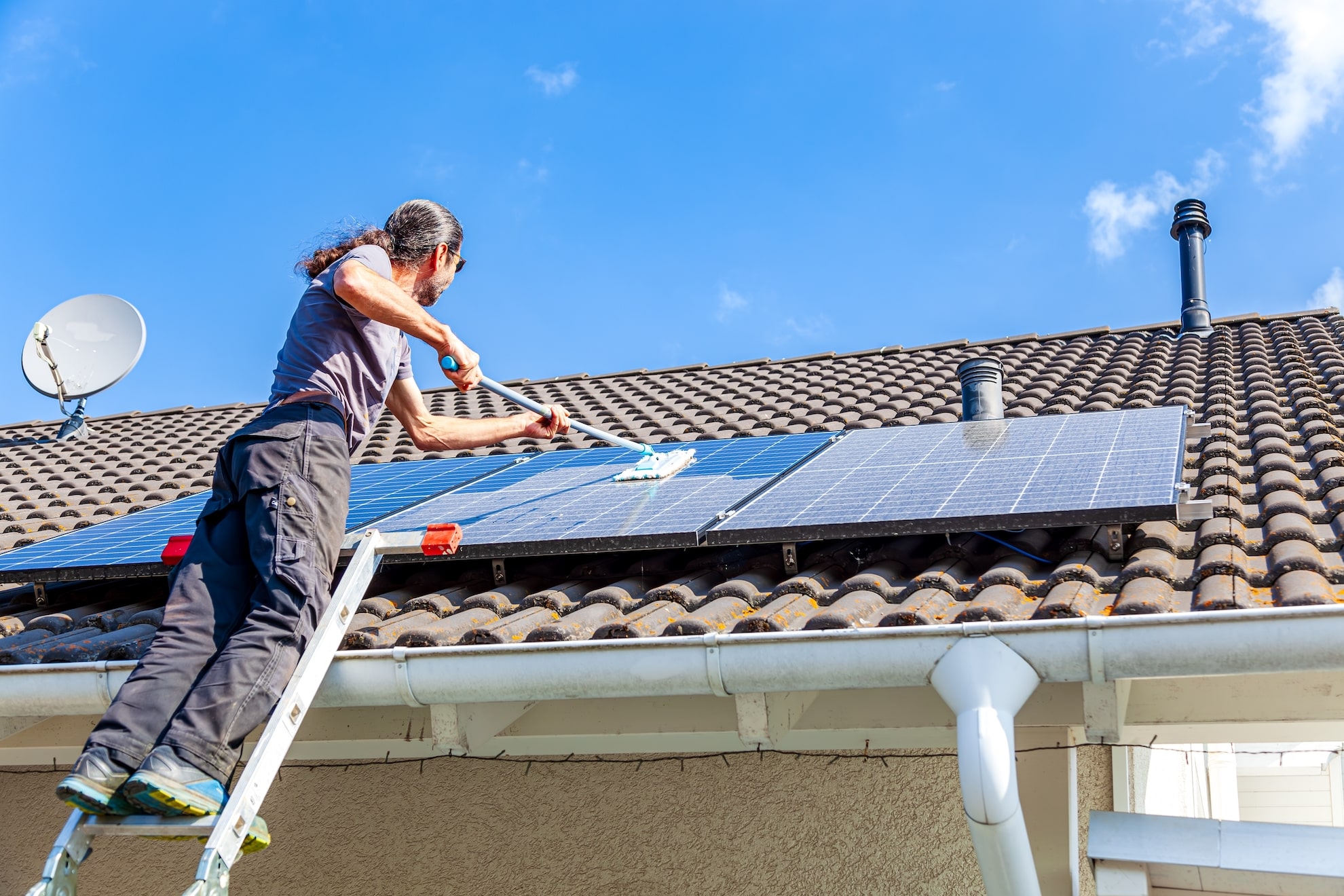 man cleaning a solar panel